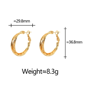 Dettaglio di orecchini a cerchio dorati con trama incrociata e misure 36,8x29,8 mm