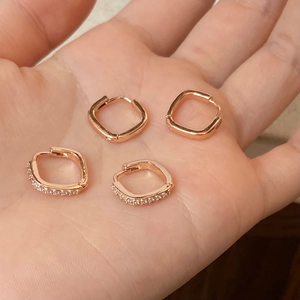 Vue macro de quatre boucles d'oreilles carrées en or rose avec pierres en zircone