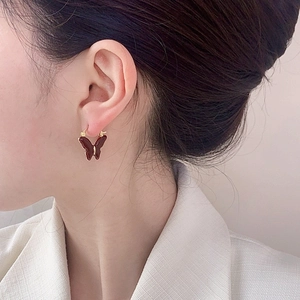 French vintage butterfly earrings with amber resin wings and gold metal hardware on model