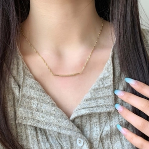 Minimalist 18K gold smile necklace with micro-pave zircons worn on a model's neck