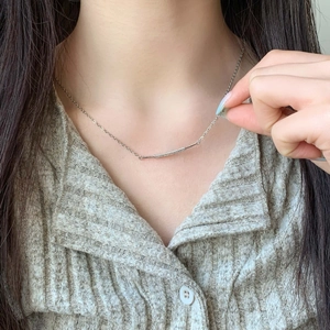 Elegant silver chain necklace featuring a curved bar pendant with micro-paved zircons