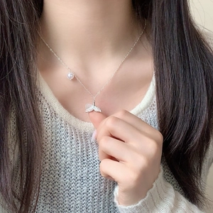 Elegante Silberhalskette mit Kristall-Fischschwanz und Perle, an einem Model gezeigt