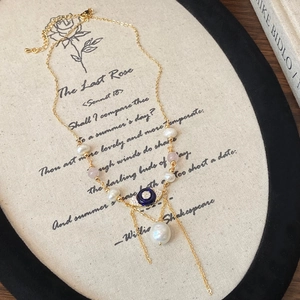 Détail d'un collier de perles multicouches avec pendentif œil et pompons sur fond rétro