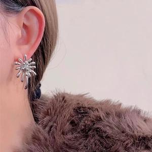Boucles d'oreilles clous géométriques argentées motif feu d'artifice sur un mannequin