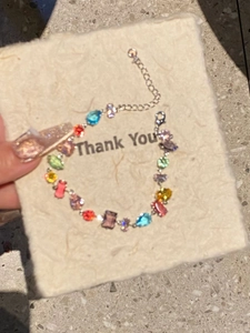 Detail of colorful crystal bracelet featuring mixed multi-shape stones and silver chain