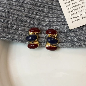 Detail of vintage stack oval stud earrings with deep red and blue resin in gold setting