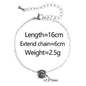 Macro detail of silver stainless steel chain with a large dark cubic zirconia gemstone