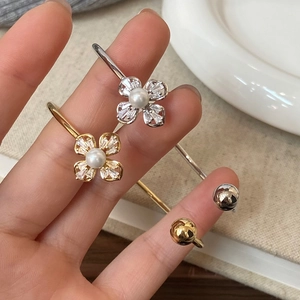 Adjustable four-leaf clover bracelet with sparkling zircon petals and central pearl in gold and silver