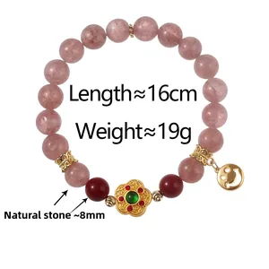 Detail of pink natural stone beaded bracelet with gold flower and smile charm