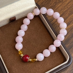 Elegant natural rose quartz beaded bracelet with strawberry crystal in a jewelry box