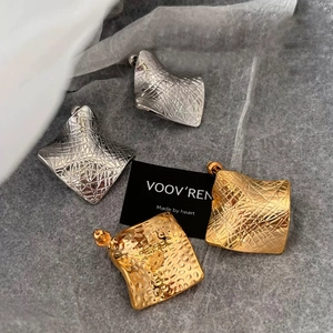 Irregular geometric square earrings with a crinkled texture in gold and silver finish