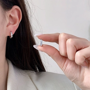 Minimalist silver zirconia hoop earrings with micro-pave setting on earlobe model