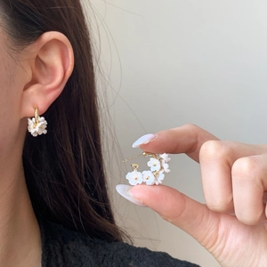 Floral hoop earrings with white shell-like petals and gold accents for women
