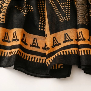 Détail d'une écharpe géométrique avec texture imprimée ethnique orange et noire