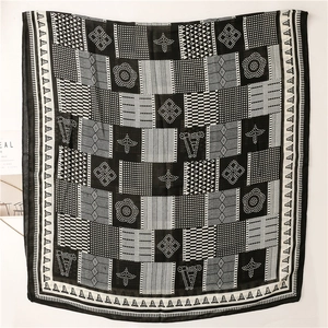 Gros plan d'une écharpe légère avec des motifs géométriques noirs et blancs à pois