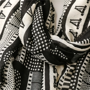 Détail macro de l'écharpe en coton et lin respirant avec motifs géométriques noir et blanc