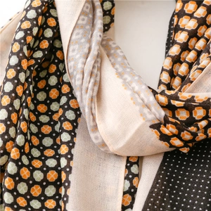 Detail of soft linen-feel scarf with clover patterns and colorful geometric prints