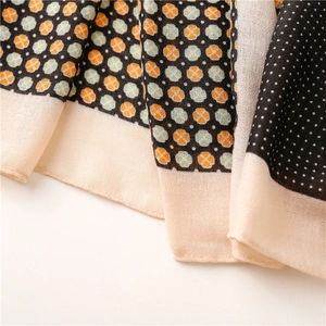 Macro detail of scarf featuring floral patterns, white polka dots, and lightweight texture