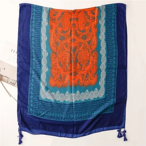 Close-up of bohemian paisley scarf featuring intricate blue tassels and geometric patterns