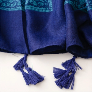 Detailed close-up of dark blue scarf featuring fringe trim and intricate woven patterns