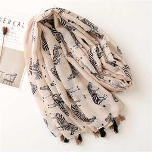 Elegant beige zebra print cotton linen scarf with tassels and artistic lifestyle props