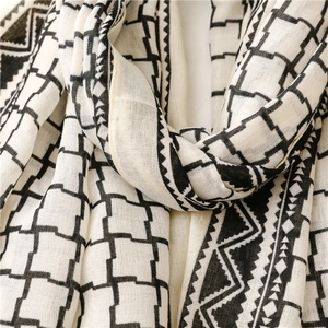 Detailed close-up of a black and white geometric pattern scarf with fine woven texture