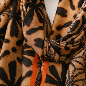 Detail shot of linen-feel scarf showing brown leopard floral pattern and fabric texture