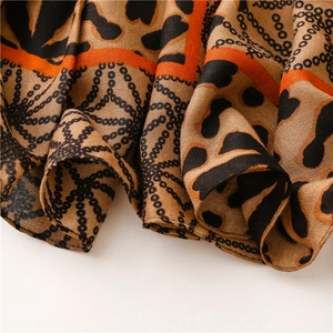 Detail of leopard print and gold chain pattern on soft cotton-linen feel shawl fabric