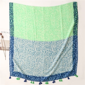 Detail of mint green paisley scarf featuring intricate floral patterns and fringe tassels