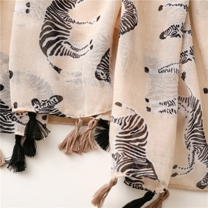 Detail of lightweight zebra print scarf showing fringe tassels and woven fabric texture