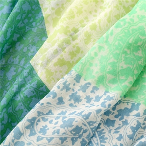 Macro shot of lightweight floral paisley scarf fabric with fresh green and blue patterns