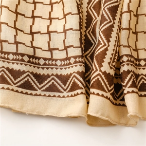 Detail of woven fabric texture and vintage geometric pattern on beige scarf shawl