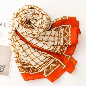 Detail of orange and brown plaid scarf showing breathable linen texture and fringe