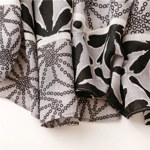 Detail of grey and black floral pattern on soft linen-feel cotton beach shawl and scarf