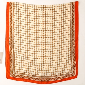 Macro detail of geometric grid patterns and orange borders on square silk scarf