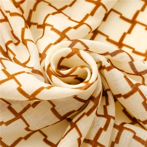 Close-up of soft plaid scarf fabric with orange geometric patterns and fine texture