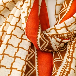 Detail of thin orange plaid scarf showing delicate ethnic geometric patterns and textures