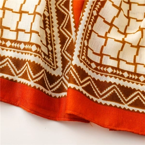 Detail shot of bohemian geometric print scarf showing soft fabric texture and orange pattern