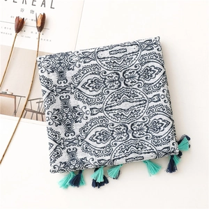 Detail of bohemian paisley shawl with blue tassels and a minimalist cereal magazine