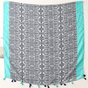 Detail of bohemian mandala print scarf featuring cyan borders and small decorative tassels