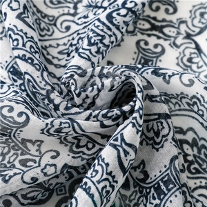 Close-up of bohemian blue paisley patterns on soft cotton-linen fabric texture
