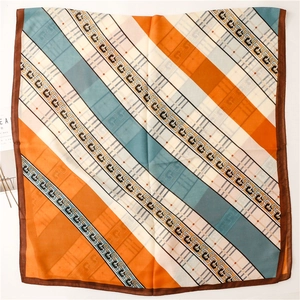 Détail de motifs géométriques entrelacés sur une écharpe en coton-lin orange et bleu