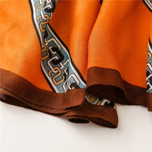 Détail d'une écharpe orange douce avec motif de chaîne et texture au toucher lin