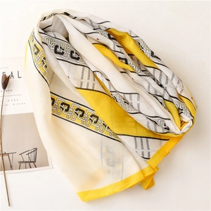 Détail d'une écharpe en coton et lin avec motifs chaînes et bordures jaunes contrastées
