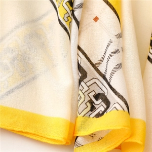Détail d'une écharpe douce à motif de chaîne avec bordure jaune et texture fine du tissu