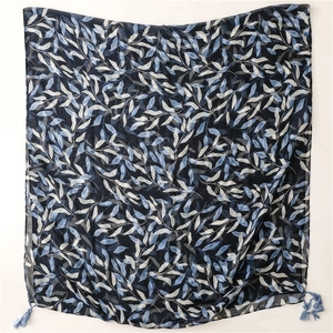 Detail of navy blue scarf featuring delicate leaf prints and blue corner tassels