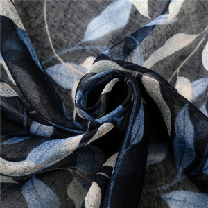 Detail of navy cotton linen scarf showing delicate light blue leaf patterns and fabric texture