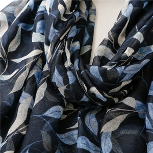 Detailed close-up of navy blue leaf print on soft, breathable cotton linen scarf fabric
