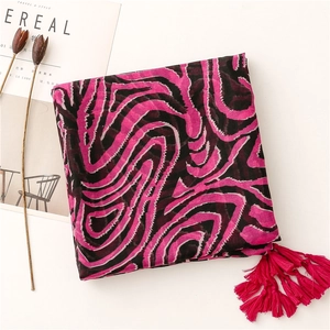 Vue détaillée de l'écharpe à motif zébré rose rouge et noir avec des franges stylées
