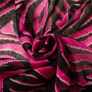 Vue macro d'un châle imprimé zèbre fuchsia montrant la texture fine du coton et du lin